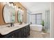 Elegant bathroom with double sinks, soaking tub, and walk-in shower at 9176 Sugarstone Cir, Highlands Ranch, CO 80130