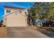 Two-story house with beige siding, brick accents, and a two-car garage at 7890 Canvasback Cir, Littleton, CO 80125