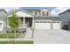 Two-story home with gray siding, white trim, and a three-car garage at 3322 N Highlands Creek Pkwy, Aurora, CO 80019