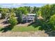 Aerial view of a ranch-style home on a large lot with mature trees and outbuildings at 5142 Buffalo Rd, Erie, CO 80516