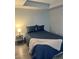 Main bedroom with a navy blue comforter and grey wood-look floors at 4899 S Dudley St # 1E, Littleton, CO 80123