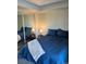 Main bedroom with a navy blue comforter and grey wood-look floors at 4899 S Dudley St # 1E, Littleton, CO 80123