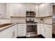 Modern kitchen with white cabinets, stainless steel appliances, and a subway tile backsplash at 11255 E 25Th Ave, Aurora, CO 80010