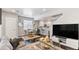 Open living room with dark hardwood floors and large TV at 11255 E 25Th Ave, Aurora, CO 80010