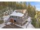 A-frame home nestled in a snowy wooded area at 30162 Pine Crest Dr, Evergreen, CO 80439