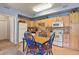 Kitchen with light wood cabinets, tiled backsplash, and a dining area at 22960 E Roxbury Dr # G, Aurora, CO 80016