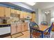 Modern kitchen with light wood cabinets, tiled backsplash and white appliances at 22960 E Roxbury Dr # G, Aurora, CO 80016