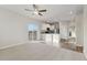 Open living room with neutral carpeting, vinyl flooring, and kitchen views at 2992 Oxley St, Strasburg, CO 80136