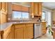 Kitchen with oak cabinets, double sink, and stainless steel dishwasher at 17769 E Iowa Dr, Aurora, CO 80017