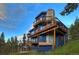 Modern mountain home exterior with multi-level decks and stone fireplace at 141 Shekel Ln, Breckenridge, CO 80424