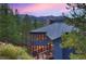 Mountain home exterior at dusk, showcasing a large deck and mountain views at 141 Shekel Ln, Breckenridge, CO 80424
