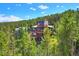 Elevated view of a stunning home with mountain backdrop and private wooded lot at 141 Shekel Ln, Breckenridge, CO 80424