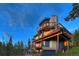 Modern home with stone fireplace and decks at dusk at 141 Shekel Ln, Breckenridge, CO 80424