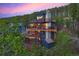 Aerial view of a modern mountain home with expansive decks and mountain backdrop at 141 Shekel Ln, Breckenridge, CO 80424