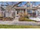 Inviting exterior of a two-story townhome with stone accents and landscaping at 7353 Norfolk Pl, Castle Pines, CO 80108