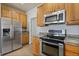 Updated kitchen with stainless steel appliances and ample wood cabinetry at 7353 Norfolk Pl, Castle Pines, CO 80108