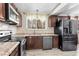 Modern kitchen with stainless steel appliances and wood cabinets at 15768 E Center Pl, Aurora, CO 80017