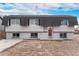 Ranch style home with gray siding, red door, and mature landscaping at 206 Cedar St, Hudson, CO 80642