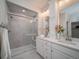 Modern bathroom featuring a walk-in shower with gray tile, dual vanity sinks, and white cabinetry at 5176 N Quemoy Ct, Aurora, CO 80019