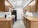 Galley kitchen with wood cabinets, stove, and refrigerator at 1830 Newland Ct # 323, Lakewood, CO 80214
