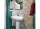 Chic powder room with pedestal sink and floral-patterned wall tile at 33 L Rd, Golden, CO 80403