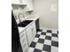Kitchen with white cabinets, black appliances, and a checkerboard floor at 12172 Huron St # 207, Denver, CO 80234