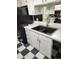 Kitchen with white cabinets, black appliances, and a checkerboard floor at 12172 Huron St # 207, Denver, CO 80234