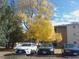 Apartment building parking lot with cars and fall leaves at 12172 Huron St # 207, Denver, CO 80234