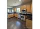 Kitchen with wood cabinets, stainless steel appliances and dark hardwood floors at 23671 E Alabama Dr, Aurora, CO 80018
