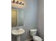 Clean bathroom with pedestal sink, toilet and light fixture at 23671 E Alabama Dr, Aurora, CO 80018