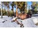 Relaxing hot tub on wooden deck nestled in snowy wooded backyard at 878 American Way, Breckenridge, CO 80424