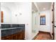 Bathroom with dark vanity, walk-in shower, and concrete floor at 2435 S Milwaukee St, Denver, CO 80210