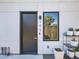 Building entrance with black door and window, flanked by planters at 3700 N Marion St # 105, Denver, CO 80205