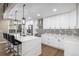 Modern kitchen with white cabinets, quartz countertops, and an island with seating at 12953 E Cornell Ave, Aurora, CO 80014