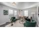 Bright living room with green velvet chairs, a neutral sofa, and a coffee table at 12048 E Canal Dr, Aurora, CO 80011