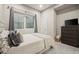 Basement bedroom with window, dresser, and comfy bedding at 6747 Raritan Dr, Denver, CO 80221