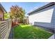 Landscaped backyard with grass, tree, and privacy fence at 6747 Raritan Dr, Denver, CO 80221
