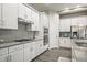 Modern kitchen with white cabinets, granite countertops, and stainless steel appliances at 6747 Raritan Dr, Denver, CO 80221