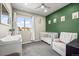 Charming Bedroom featuring a crib, changing table, and accent wall at 6747 Raritan Dr, Denver, CO 80221