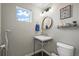 Stylish powder room with a floating vanity and round mirror at 6747 Raritan Dr, Denver, CO 80221