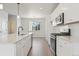 Modern kitchen with white cabinets, quartz countertops, and stainless steel appliances at 461 Interlocken Blvd # 103, Broomfield, CO 80021