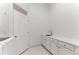Laundry room with white cabinets, a sink, and a door for added storage at 4381 Cheyenne Dr, Larkspur, CO 80118