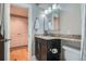 Clean bathroom with granite countertop, dark vanity, and built-in mirror at 2460 W Caithness Pl # 104, Denver, CO 80211
