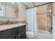 Updated bathroom with granite vanity, shower/tub combo, and tile surround at 2460 W Caithness Pl # 104, Denver, CO 80211