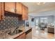 Modern kitchen features granite countertops, stainless steel appliances, and stylish backsplash at 2460 W Caithness Pl # 104, Denver, CO 80211