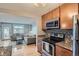 Modern kitchen with stainless steel appliances and view into living room at 2460 W Caithness Pl # 104, Denver, CO 80211