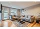 Living room features hardwood floors, a comfortable sofa, and access to a patio at 2460 W Caithness Pl # 104, Denver, CO 80211