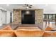 Basement living area with stone feature wall and TV at 1082 W Meadow Rd, Evergreen, CO 80439