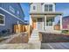 Two-story gray house with orange door, wooden fence, and small front yard at 10291 E 62Nd Pl, Denver, CO 80238