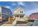 Two-story gray house with orange door, wooden fence, and small front yard at 10291 E 62Nd Pl, Denver, CO 80238